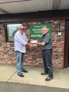 two men clasping hands in front of a building