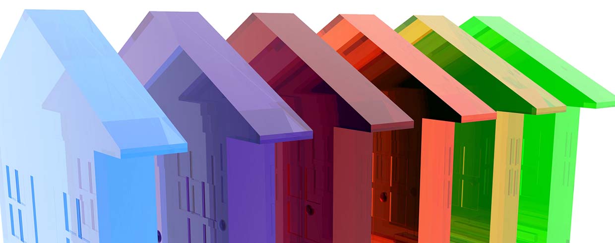 Concept image of acrylic houses lined up in all colors of the rainbow.